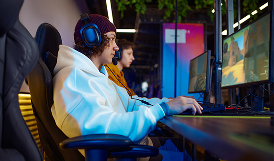 Two teenagers gaming on computers