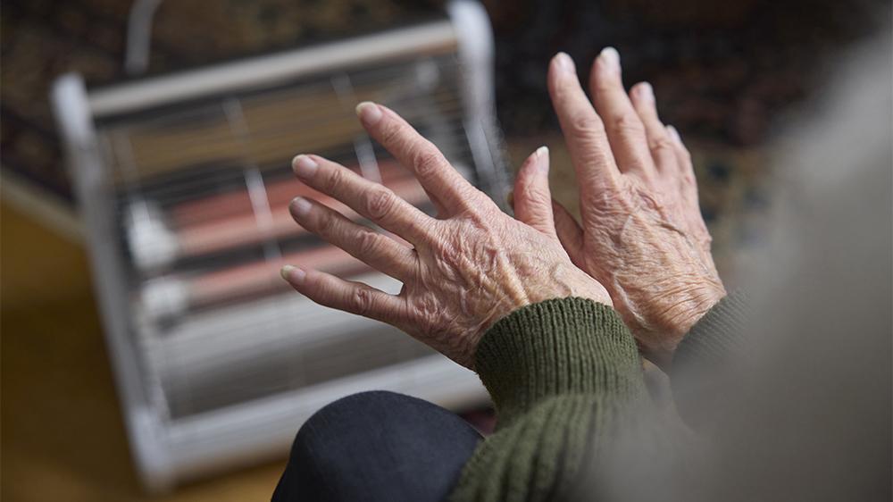 Person warming hands in front of a domestic heater