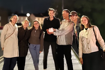 Seven smiling, young adults outdoors