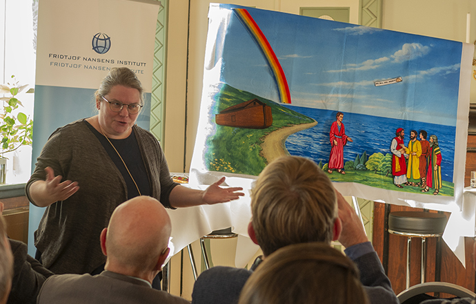 Dame, ved siden av en flanellograf, prater til forsamling